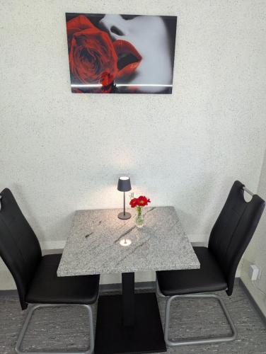 a table with two chairs and a vase of flowers on it at Apartment in Lehrte