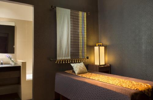 a bedroom with a bed with a window and a lamp at Best Western Premier La Grande Bandung in Bandung