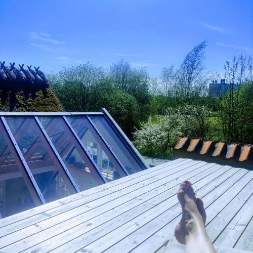 a persons feet on the roof of a house at Eget anneks på landet, tæt på skov og strand in Græsted