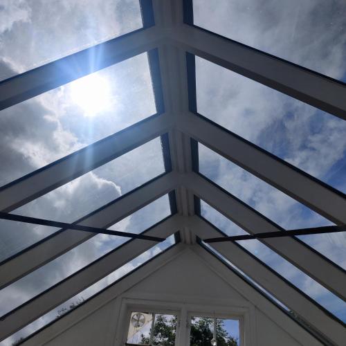 a glass ceiling in a house with the sky in the background at Eget anneks på landet, tæt på skov og strand in Græsted