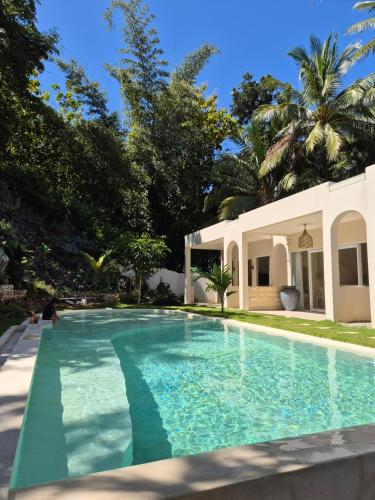 a swimming pool in front of a house at Summerforest Watukarung in Watukarung