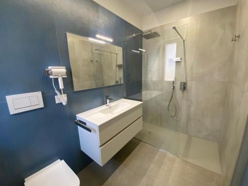 a bathroom with a sink and a shower and a toilet at L'Altalena Guest House in Lido Di Fondi