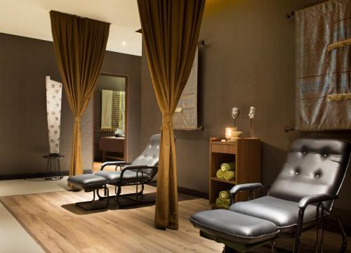 a salon with chairs and a mirror and curtains at Best Western Premier La Grande Bandung in Bandung