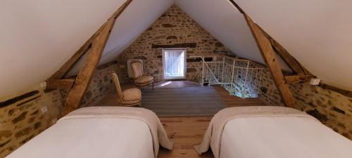 a attic room with two beds and a staircase at La petite maison de Marigné in Moulins