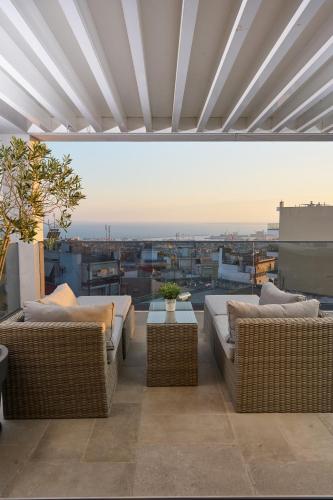 a patio with two couches and a table on a roof at SIGMA Suites Hotel in Thessaloniki