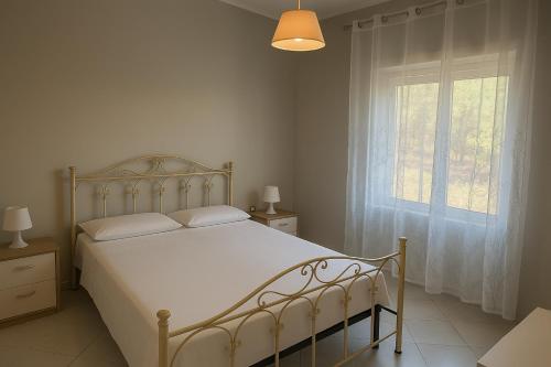 a bedroom with a white bed and a window at Villa Lesina Casa Vacanze in Santa Maria di Castellabate