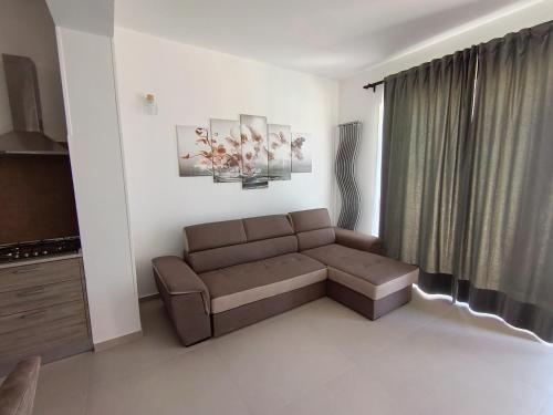 a living room with a brown couch in front of a window at Villa Nunzia in Ostuni