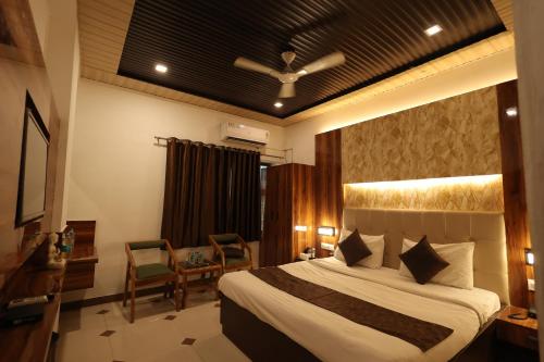 a bedroom with a bed and a table and chairs at Yashogopal Resortico in Vrindāvan
