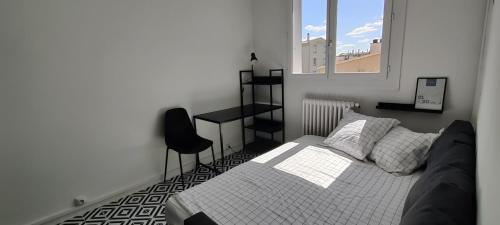 une chambre avec un lit, une chaise et une fenêtre dans l'établissement Chez Fred and Nico, à Colomiers