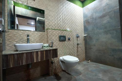 a bathroom with a sink and a toilet at Yashogopal Resortico in Vrindāvan