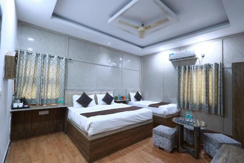 a hotel room with two beds and a table at Yashogopal Resortico in Vrindāvan