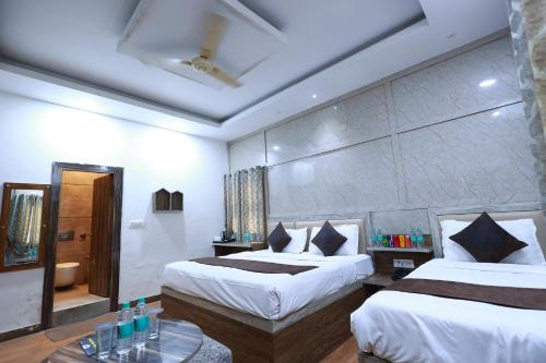 a hotel room with two beds and a table at Yashogopal Resortico in Vrindāvan