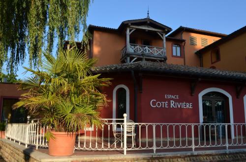 a coffee house with a white fence in front of it at Les Saules Parc & Spa - Teritoria in Vonnas