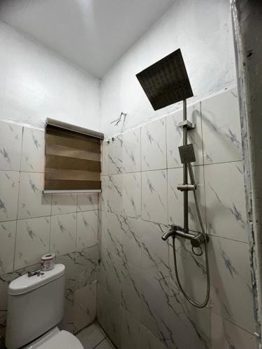 a bathroom with a shower and a toilet at Utako Studio Apartments-City Center in Abuja