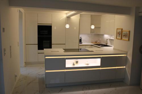a large kitchen with white cabinets and a sink at Schicke Ferienwohnung für 2 in Niederkalbach