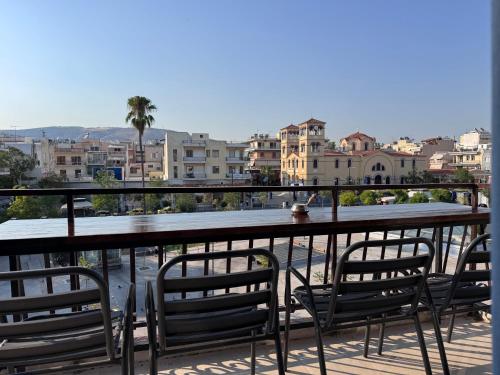 a table and chairs on a balcony overlooking a city at BLUE LINE Coliving in Piraeus