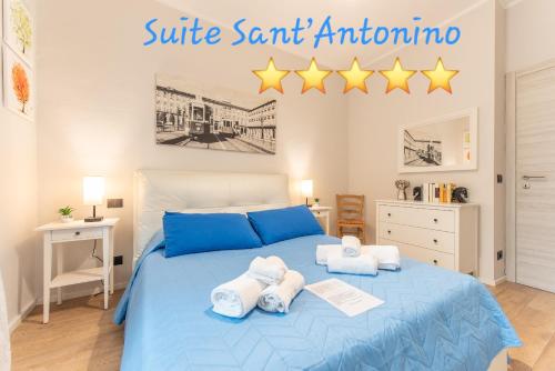 Un dormitorio con una cama azul con toallas y cinco estrellas. en SUITE SANT ANTONINO 12 min di Metro e sei in Centro, en Turín