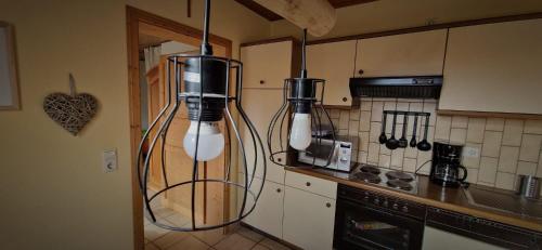 a kitchen with two white bottles hanging from the wall at Ferienwohnung Odenwaldliebe in Grasellenbach