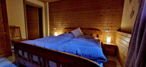 a bed in a room with a wooden wall at Ferienwohnung Odenwaldliebe in Grasellenbach