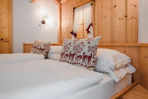 a bed in a room with wooden walls at Hotel Des Alpes in Soraga