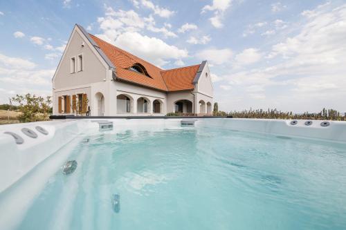 a large swimming pool in front of a house at PALO Borbirtok - Bed and Wine in Paloznak