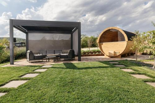a gazebo with a bench and a table in a yard at PALO Borbirtok - Bed and Wine in Paloznak