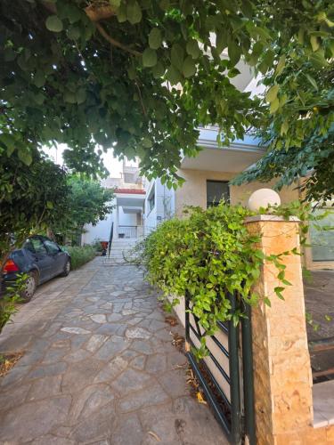 a stone path in front of a house with a fence at Odyssey Mare Steps from the Sea in Perea