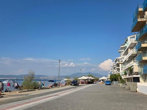 a city street with a building and a beach at Odyssey Mare Steps from the Sea in Perea