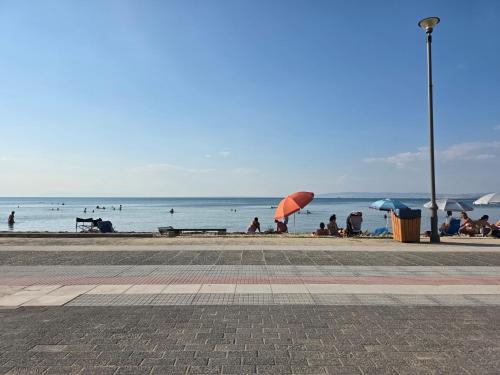 a group of people sitting on the beach with umbrellas at Odyssey Mare Steps from the Sea in Perea