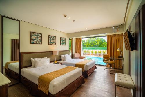 pokój hotelowy z 2 łóżkami i dużym oknem w obiekcie The Isabelle Hotel w mieście Naga