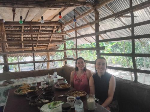 a man and woman sitting at a table with food at Sigiri Panaromic Tree House in Sigiriya