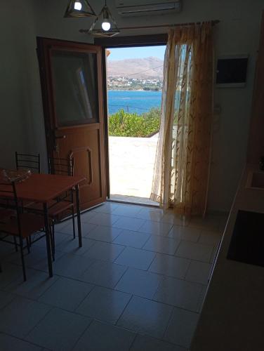 a dining room with a table and a view of the ocean at Akrogiali Rooms & Studios in Drymonas