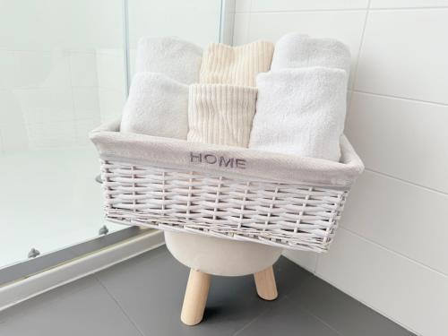 a basket of towels on a stool in a bathroom at Deny & Carol's house in Somma Lombardo