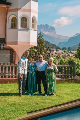 a group of people standing in front of a house at Hotel Des Alpes in Soraga