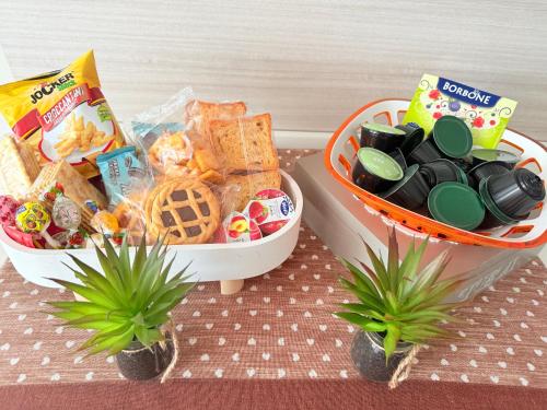 two baskets filled with snacks and crackers and some plants at Deny & Carol's house in Somma Lombardo