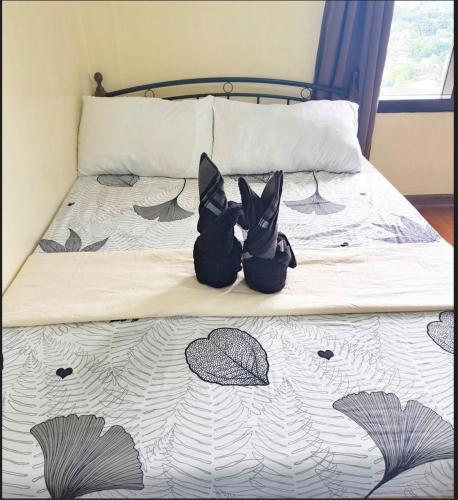 two shoes sitting on top of a bed at 1BEDROOM CONDO AZALEA WITH FREE WIFI in Tabok