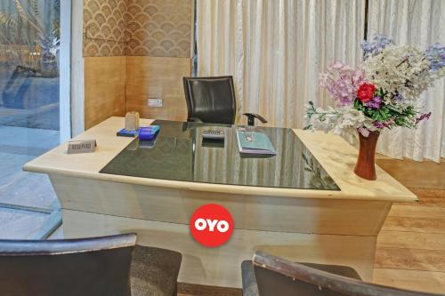 an office with a desk with a vase of flowers at Hotel O M & M Hospitality in Bengaluru