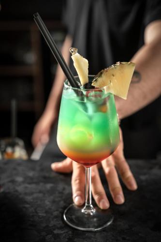 a person is holding a drink on a bar at Hotel Grazia Riccione in Riccione