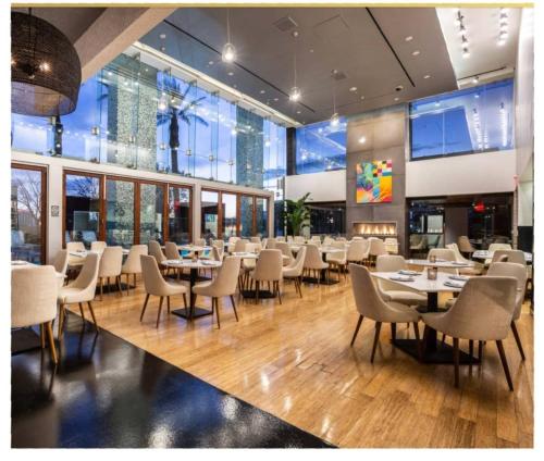 a dining room with tables and chairs and windows at Luxe Condo Free Parking No Resort Fees in Las Vegas