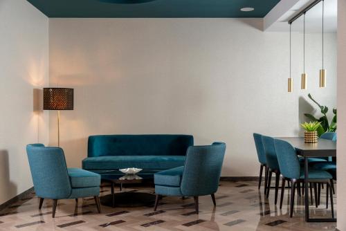 a living room with a blue couch and chairs at Hotel Grazia Riccione in Riccione