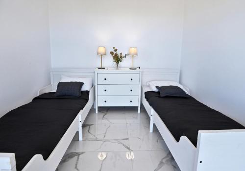 a bedroom with two beds and a dresser at Villa Almar in Adamas