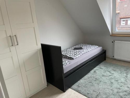 a small bedroom with a bed in the corner at Monteurwohnung - Bertholdstraße 19 in Pforzheim