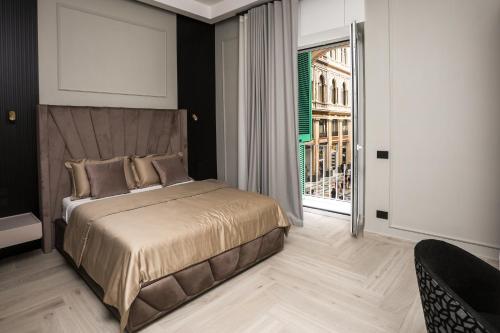 a bedroom with a bed and a large window at LUNA Gallery Suites in Naples