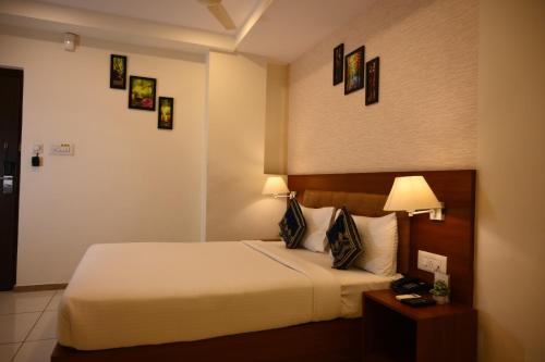 a hotel room with a bed and a table with a lamp at Classio inn Hotel - Near Kempegowda International Airport Bangalore Terminal 1 & 2 in Bengaluru