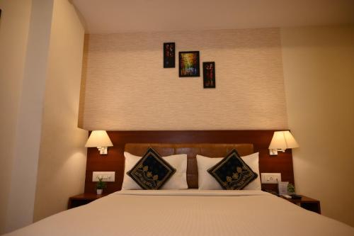 a bedroom with a bed with three pictures on the wall at Classio inn Hotel - Near Kempegowda International Airport Bangalore Terminal 1 & 2 in Bengaluru