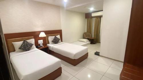 a hotel room with two beds in a room at Classio inn Hotel - Near Kempegowda International Airport Bangalore Terminal 1 & 2 in Bengaluru