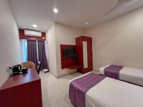 a hotel room with two beds and a television at Classio inn Hotel - Near Kempegowda International Airport Bangalore Terminal 1 & 2 in Bengaluru