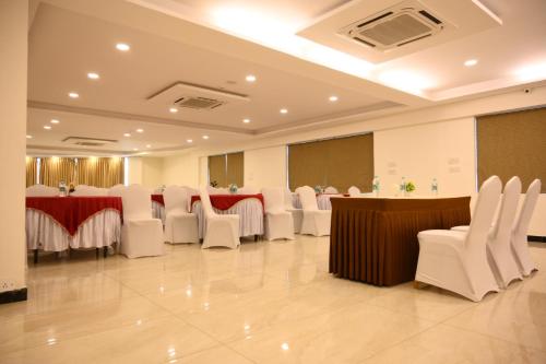 a banquet hall with white chairs and tables in a room at Classio inn Hotel - Near Kempegowda International Airport Bangalore Terminal 1 & 2 in Bengaluru