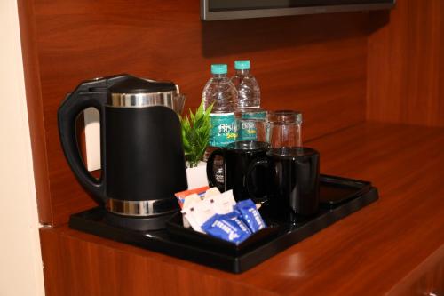a coffee maker on a shelf in a hotel room at Classio inn Hotel - Near Kempegowda International Airport Bangalore Terminal 1 & 2 in Bengaluru