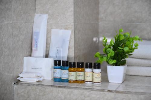 a shelf with four bottles of essential oils and a plant at Classio inn Hotel - Near Kempegowda International Airport Bangalore Terminal 1 & 2 in Bengaluru